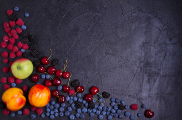 Delicious ripe fruits and berries on black background, close-up. Fruit banner. Selection of healthy vegetarian food, detox or diet concept, space for text. View from above, top studio shot