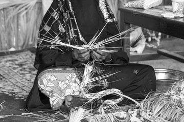 Emirati woman is in the process of weaving traditional basket