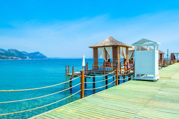 Wooden beach pavilions on the shore of a sandy beach