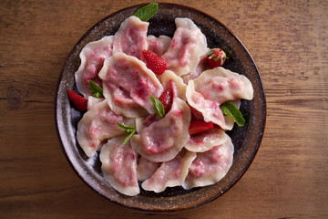 Dumplings, filled with strawberries, berries. Pierogi, varenyky, vareniki, pyrohy - dumplings with filling, popular dish in many countries. overhead, horizontal