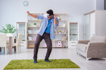 Man with virtual reality glasses playing at home