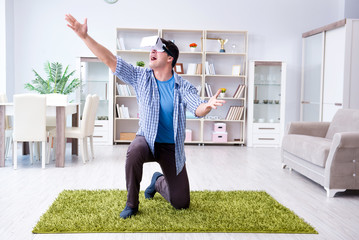 Man with virtual reality glasses playing at home