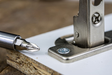 Mounting hinges for chipboard furniture. Joinery accessories used when assembling kitchen furniture.