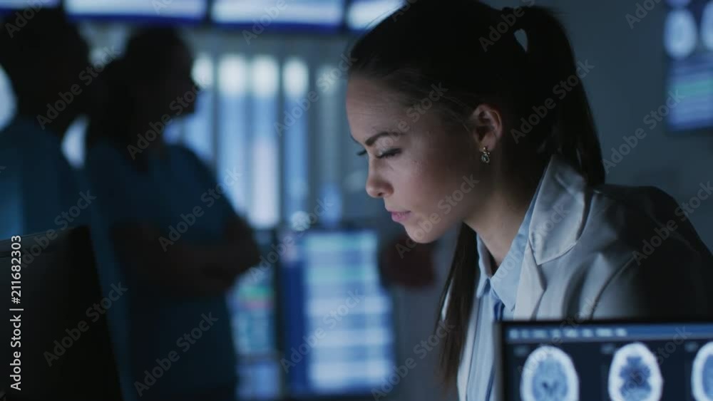 Poster female medical research scientist / neurologist working on a personal computer in modern laboratory.