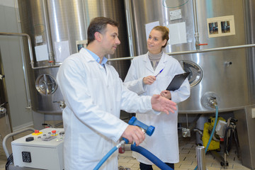 Fototapeta premium cheerful man and woman wearing uniform factory workers