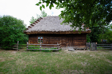 Wooden house with a thatched roof in the village