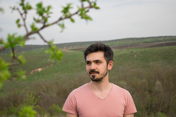 Portrait of a young man on a background of nature, spring, summer. Romantic look.