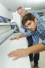 worker using a large format ink jet printer