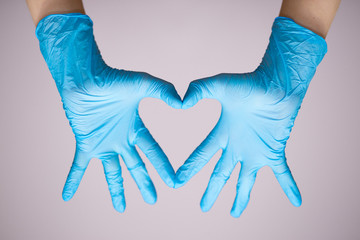 Hand in blue medical glove with Heart symbol isolated on white background