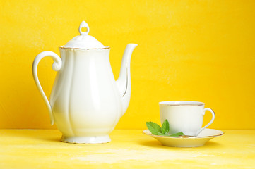 Cup of tea kettle on yellow