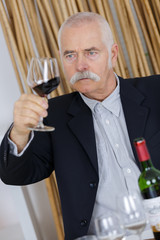 senior man tasting drinking red wine