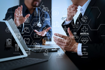 Medical co working concept,Doctor working with smart phone and digital tablet and laptop computer to meeting his team in modern office at hospital