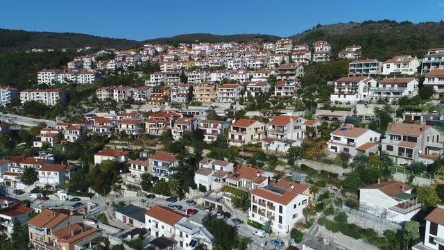 Tilting drone shot of luxurious apartment buildings and residential housing, built on a mountain slope in Rabac, property and real estate investment Croatia, Europe