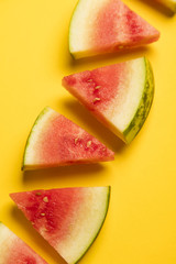 Fresh sliced watermelon on a bright yellow background