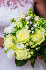 Bride holding white wedding bouquet of roses, closeup