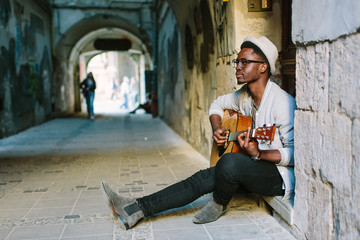 African musician playing guitar in the city