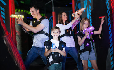 Obraz na płótnie Canvas Kids with parents during lasertag game