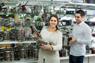 couple chooses pans in shop cookware