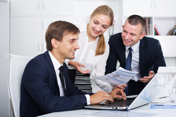 Fototapeta premium Three glad business workers holding documents