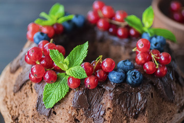 Chocolate cake with chocolate icing, mint  and fresh berries.