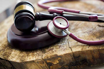 Medical law concept. Gavel and stethoscope on wooden table