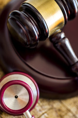 Medical law concept. Gavel and stethoscope on wooden table