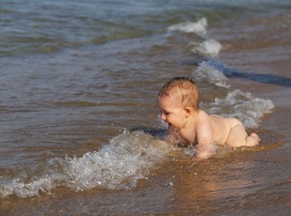 Baby boy playing in the water.