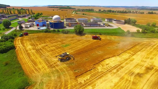 Aerial view of combine harvester. Harvest of wheat field. Industrial background on agricultural theme. Biofuel and food production from above. Agriculture and environment in European Union. 