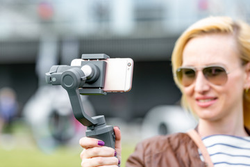 the girl with the phone on the stabilizer leads the videoblog. She takes herself to the camera...