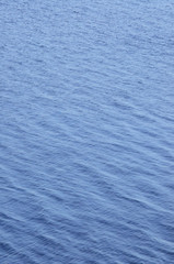 Vertical ocean water waves background pattern, abstract blue gentle bokeh bright ripples texture, scenic vibrant seascape summer season surface, large detailed copy space wallpaper