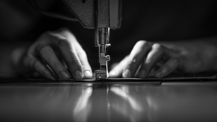 a man at work on a sewing machine. without a face. - obrazy, fototapety, plakaty