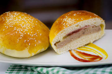 Hambúrguer. sanduíche pão recheado com carne presunto e queijo em uma mesa decorada