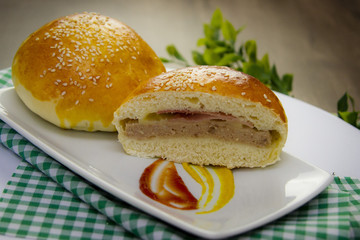 Hambúrguer. sanduíche pão recheado com carne presunto e queijo em uma mesa decorada