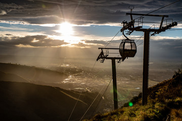 Sunlight breaks through the cloud and lights up the city below the cable cars © Sheryl