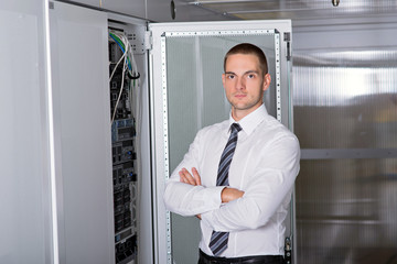 Young handsome business man engeneer in datacenter server room