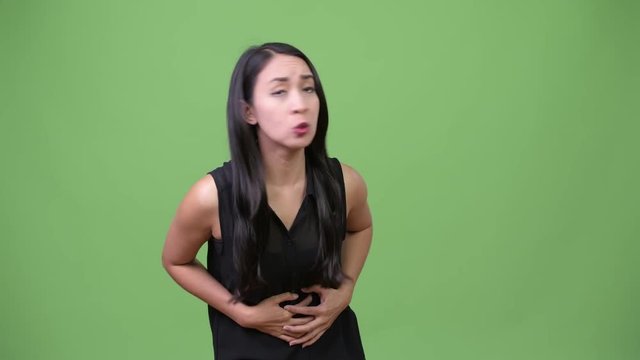 Young beautiful Asian businesswoman having stomach ache