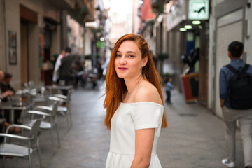 Portrair of young redhead pretty girl in the street