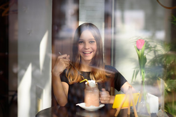 girl drinks coffee and watches video on mobile phone