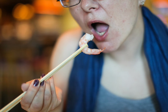 Croped picture of Caucasian Woman eating in Asian restaurant snack with shrimps. Woman in lovely place having lunch.