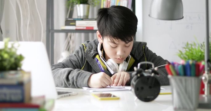 Young asian teenage student doing homework at home, Dolly move right to left.