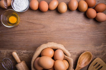 Fresh farm eggs on a wooden rustic background, Whipping eggs and whisk,top view with copy space