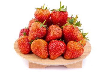 Heap of fresh strawberries in ceramic bowl  on the wooden tray.