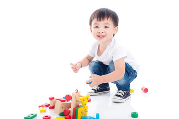 Little asian boy playing toy on the floor over white background