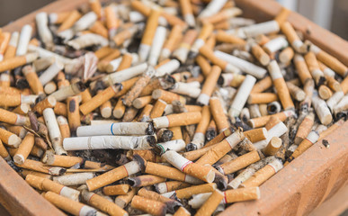 Cigarettes on smoking area.full of cigarette ends.Stop smoking concept.Anti cancer theme.
