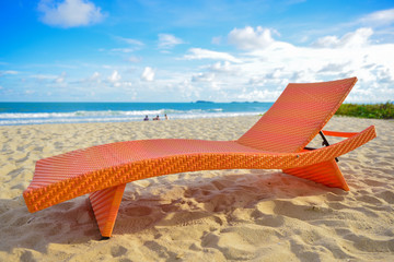 Fototapeta na wymiar Orange chair on beach at holiday.