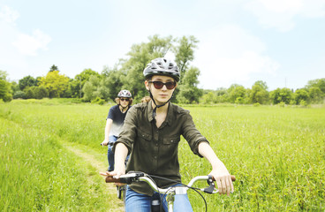 Teenagers on their bikes in meadow trail. Cycle ride in countryside