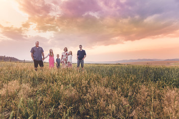 Family walking in a field in a sunset quality family time