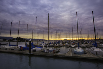 beautiful picture of a sunrise or sunset in a boat marina with sail boats
