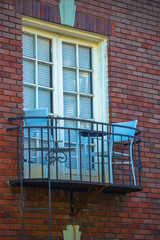 Fototapeta na wymiar Tiny balcony with chairs and table on building