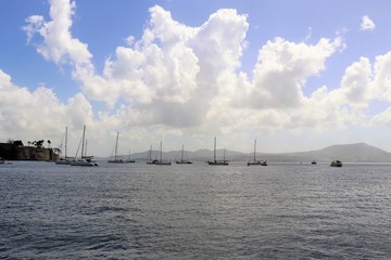 Fototapeta premium Sailboats on the ocean with a beautiful blue sky and puffy white cloud background